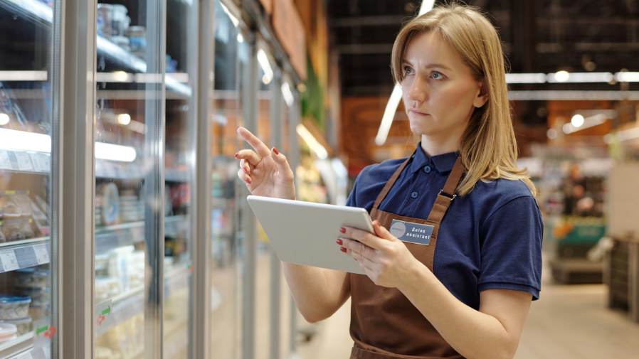 Business owner reviewing POS data analytics dashboard in retail store